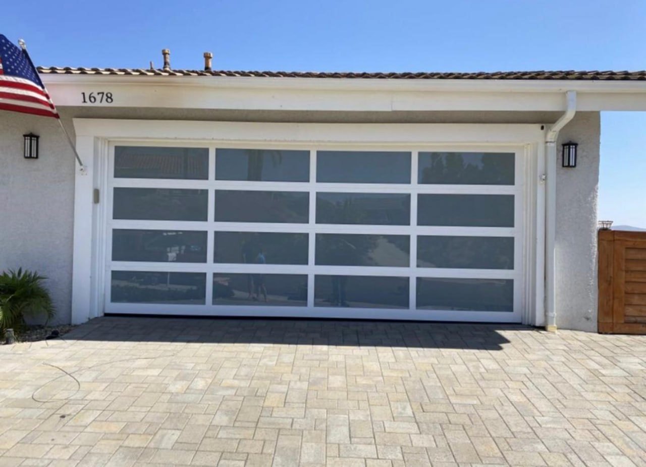 Modern full-view glass garage door installed by Safe Guard on a home exterior